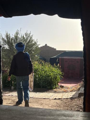 a person walking down a dirt road at Traditional nomad camp in Merdani