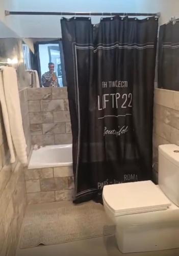 a bathroom with a black shower curtain and a toilet at Zen Townhouse - Infinity Seaview in Palaiokastro