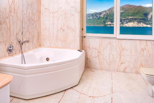 a white bath tub in a bathroom with a window at Villa Incanto Adults Only in Brenzone sul Garda