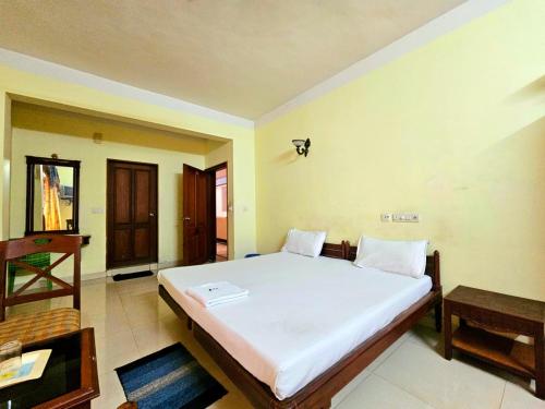 a bedroom with a large white bed in a room at PTC Residency in Alleppey