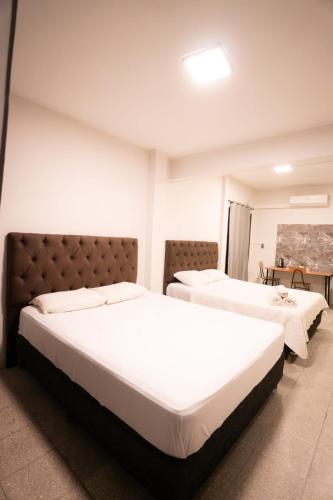 two beds in a hotel room with white sheets at Boutique 1970 Hotel in Asunción