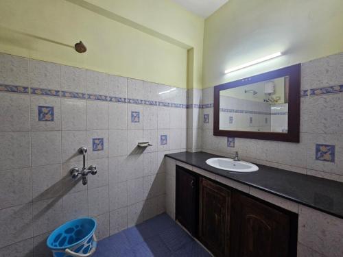a bathroom with a sink and a mirror at PTC Residency in Alleppey