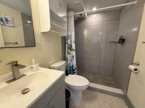 a bathroom with a sink and a toilet and a shower at Manatee Bay Inn in Fort Myers Beach