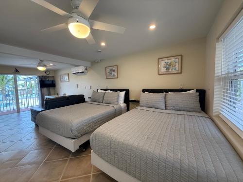 a bedroom with two beds and a ceiling fan at Manatee Bay Inn in Fort Myers Beach