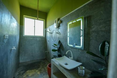 a bathroom with a sink and a mirror at Singhe House in Dickwella