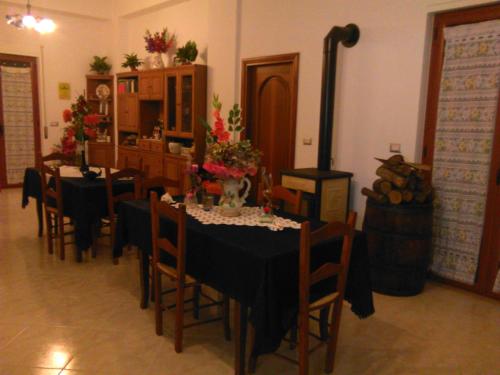 a dining room with tables and chairs and a stove at L'Oasi in Auletta