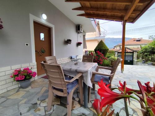 a table and chairs on a patio with flowers at Artur's Apartment in Gjirokastër