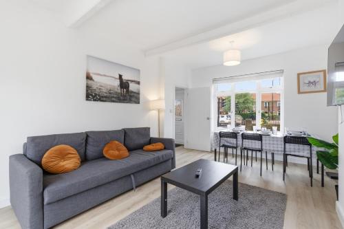 a living room with a couch and a table at Large, Bright 4 Bed Home with Garden in Kenton