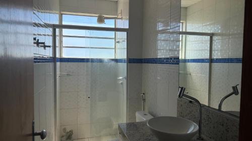 a bathroom with a glass shower and a sink at Flat Bela Amarração in Luis Correia