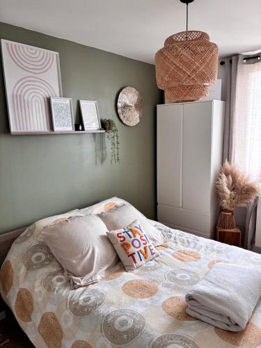 a bedroom with a bed with pillows on it at Appartement Cosy Beauvais in Beauvais