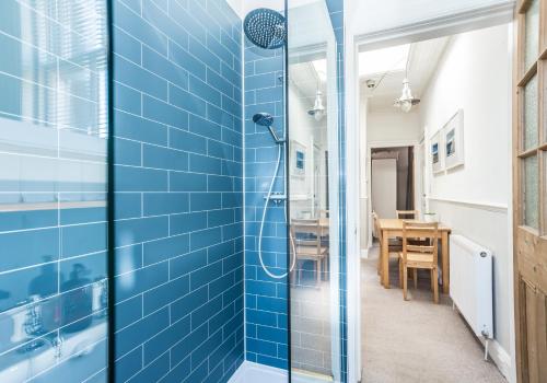 a blue tiled shower in a bathroom with a table at The Neuk in North Berwick