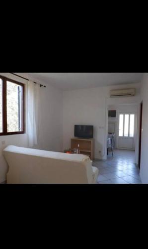 a living room with a white bed and a couch at podskoj apartment in Saplunara