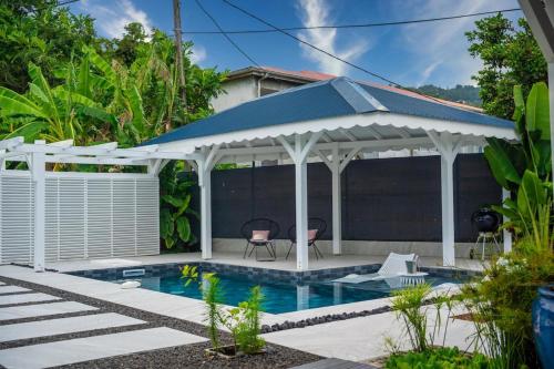 a pavilion over a swimming pool in a house at Villa Girafe Bleue 2 Suites Pool & Garden in Gourbeyre