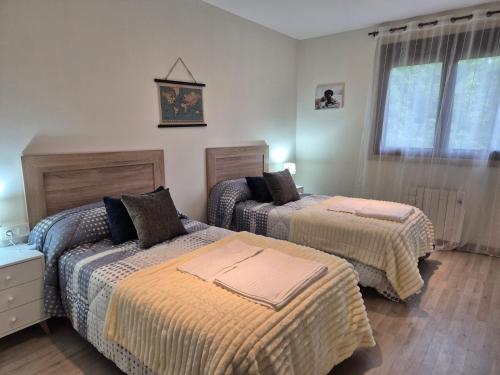 ein Schlafzimmer mit zwei Betten und einem Fenster in der Unterkunft Checoira in Ourense