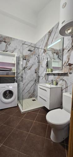 a bathroom with a toilet and a washing machine at Apartmani Meri in Supetar