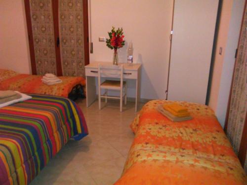 a room with two beds and a table with a table at L'Oasi in Auletta