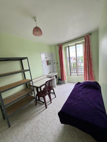 a bedroom with a bed and a desk and a table at Hostel Wilson in Saint-Denis