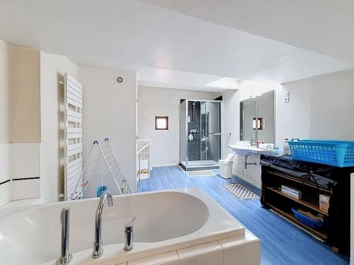 a large white bathroom with a tub and a sink at Maison de bourg - Charmante & Authentique , PLAUZAT in Plauzat
