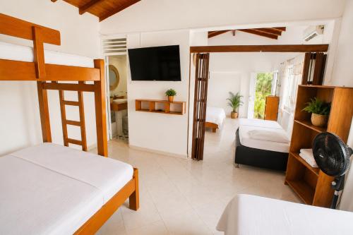 a bedroom with two bunk beds and a tv at Hotel Manglares in Capurganá