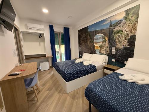 a hotel room with two beds and a desk at B&B MARE E POESIA Salerno in Salerno