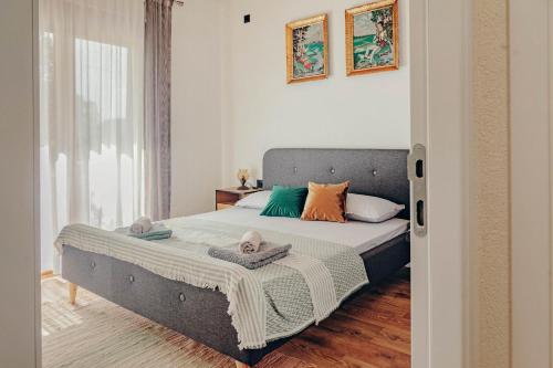 a bedroom with a bed with pillows on it at Museum Draginë-Guest House in Sukobin