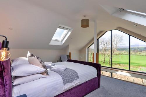 a bedroom with a large bed and large windows at Finest Retreats - Cae Rhug in Llanuwchllyn