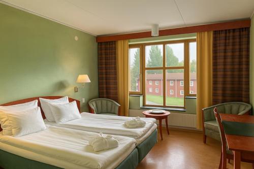 a hotel room with two beds and a window at Saxnäsgården Hotell in Saxnäs