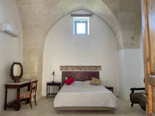 a bedroom with a bed and a window in a building at Masseria Galeasi in Grottaglie
