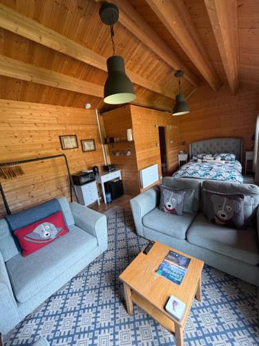 a living room with two couches and a bed at Modern Summerhouse in Lymington
