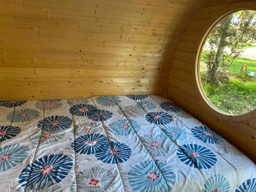 a bed in a room with a window at Insolite hobbit in Saint-André-dʼAllas