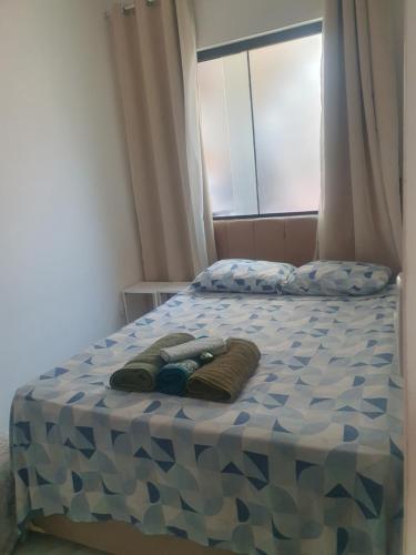 a bed with two towels on top of it at Quarto & Conforto in Penha