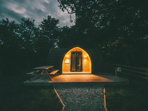 a small house with a picnic table in front of it at Castle Brake Holiday Park in Woodbury