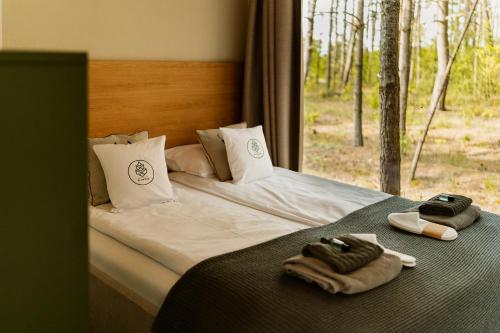 a bedroom with a bed with towels and a window at w lesie in Skrwilno
