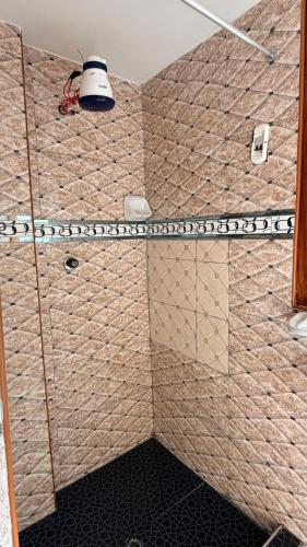 a bathroom with a shower with brown tiles at Mayupata home in Cusco