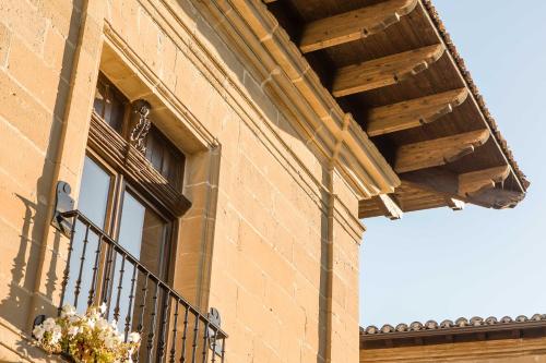 a window on a brick building with a balcony at Teatrisso Hotel Palacio in Cuzcurrita-Río Tirón