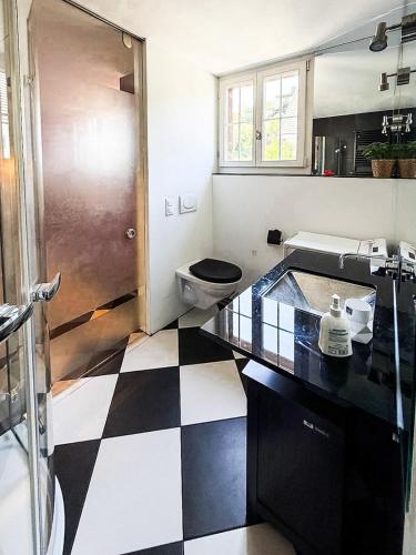 a bathroom with a black and white checkered floor at LaVida Panorama Thunersee, Wellness Oasis, Mountains in Thun