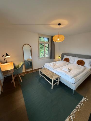 a bedroom with a bed and a table and a mirror at LaVida Panorama Thunersee, Wellness Oasis, Mountains in Thun