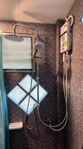 a shower in a bathroom with a shower at ริมแควโฮมสเตย์ กาญจนบุรี in Ban Pong Pat