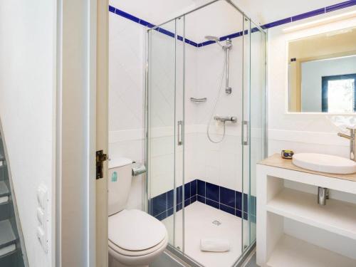 a bathroom with a toilet and a glass shower at Villa Sunshine in Vale do Lobo