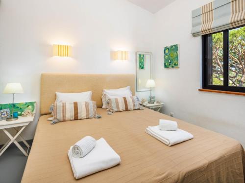 a bedroom with a large bed with two towels on it at Villa Sunshine in Vale do Lobo