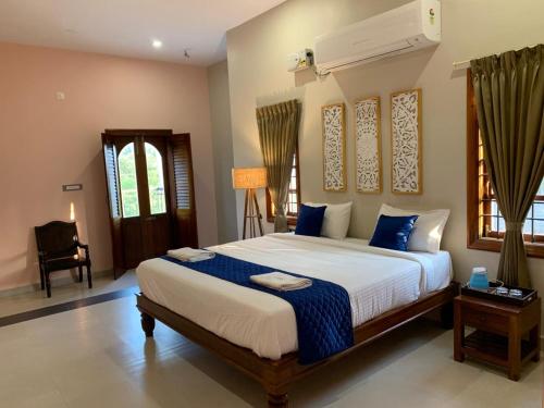 a bedroom with a large bed with blue pillows at Desert Beach House with swimming pool in Kuilapayam