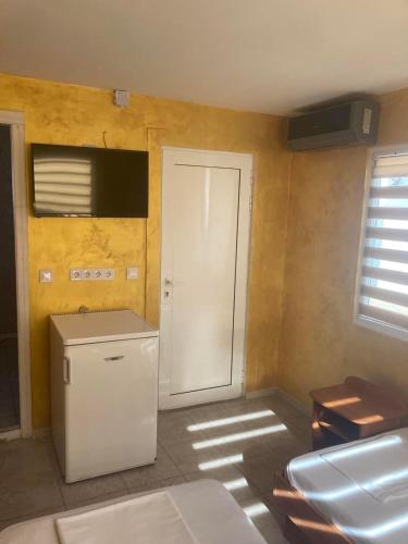 a kitchen with a white refrigerator and a door at Бунгала в Поморие in Pomorie