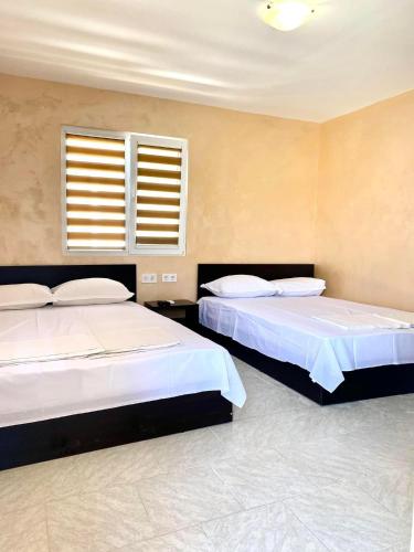 a bedroom with two beds and a window at Бунгала в Поморие in Pomorie