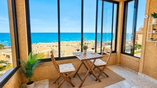 a table and chairs in a balcony with a view of the ocean at Chalet a orillas del mar in Torrevieja