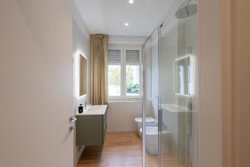 a bathroom with a toilet and a sink and a window at Dante Suites in Pergola