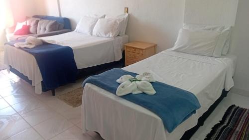 a hotel room with two beds with towels on them at Apartamento A 43 Flat Centro in Mogi das Cruzes