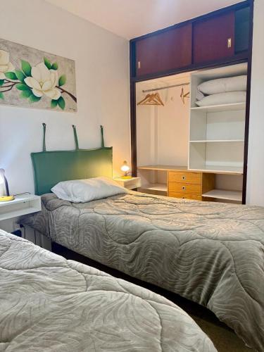 a bedroom with two beds and a dresser at depto "A" 1 dormitorio centro in Trelew