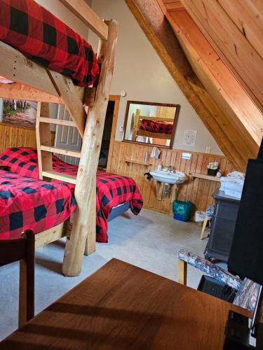 a room with two bunk beds and a sink at Domaine Valga in Saint-Gabriel