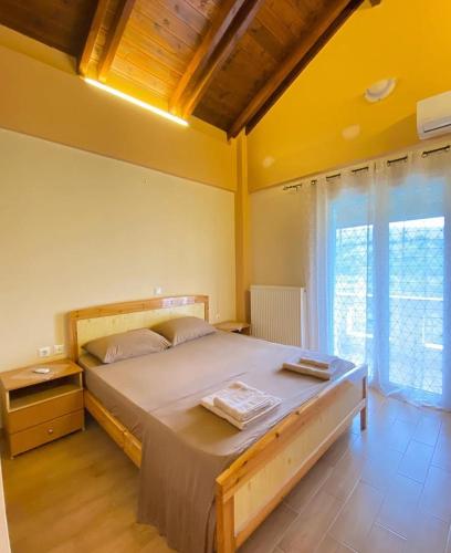 a bedroom with a large bed and a large window at Family Home in Amarynthos