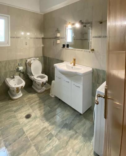 a bathroom with a toilet and a sink and a toilet istg at Family Home in Amarynthos